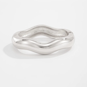 Detailed view of the hinge and invisible clasp on a polished water drop metal bangle