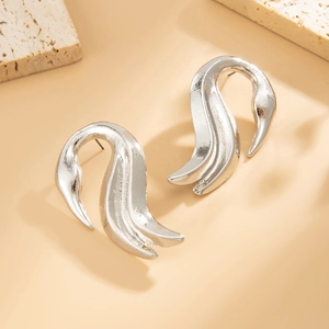Minimalistische silberne Wellenohrringe mit poliertem Metallic-Finish auf Steingrund