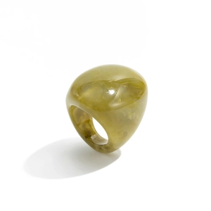 Macro detail of chunky translucent olive green resin ring with smooth rounded contours
