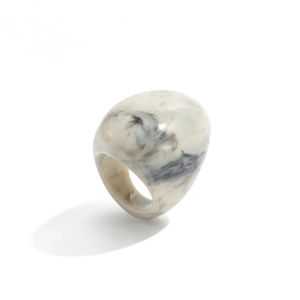 Macro shot of minimalist resin ring with gray and black marble ink texture on white