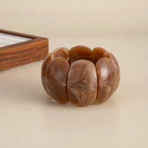 Detailed view of elastic amber marble acrylic bracelet with oval geometric resin links