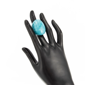 Macro view of a blue marble resin ring displayed on a black jewelry mannequin hand