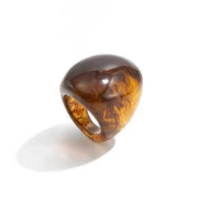 Macro detail of amber resin ring featuring brown smoke patterns and rounded wide surface