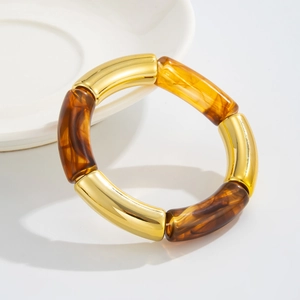 Detalle de pulsera estilo bambú con segmentos dorados y eslabones de resina ámbar jaspeada