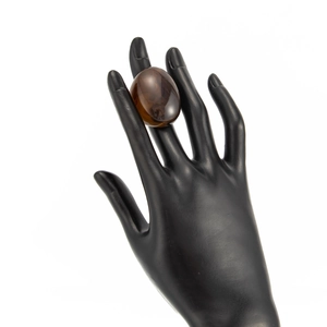 Detailed view of an oval amber resin ring on a black model stand with a high-gloss finish