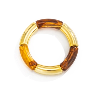 Primer plano de tubos curvados de resina de leopardo y metal dorado en pulsera elástica