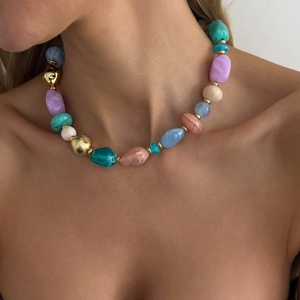 Close-up of a multi-colored irregular resin bead necklace with gold metallic accents