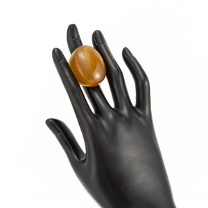Macro detail of oval amber resin ring showing translucent golden brown texture and gloss