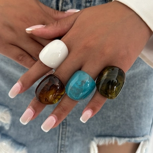 Maillard style chunky resin rings in amber, blue, and green on denim background