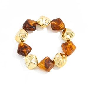 Macro shot of geometric acrylic resin beads with amber marble texture and gold accents