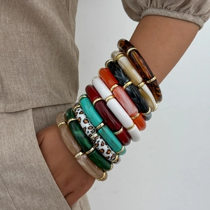 Detail von gestapelten Acryl-Harz Armbändern mit goldenen Metallverbindern in vielen Farben