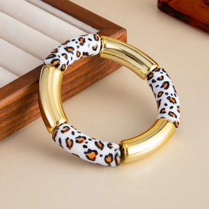 Detalle de pulsera elástica de resina con estampado de leopardo y segmentos de metal dorado