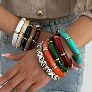 Stacked leopard print acrylic bamboo bracelets with gold metal accents on model wrist