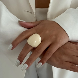 Minimalist cream resin dome ring featuring a chunky aesthetic on a female model