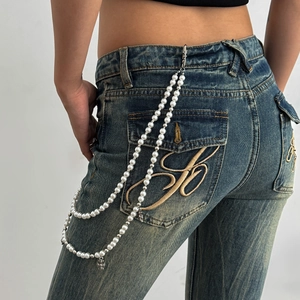 Chaîne de pantalon punk en perles avec pendentifs croix argentés sur un jean