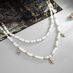 Vue détaillée du collier double couche en perles gothiques avec pendentifs croix argent