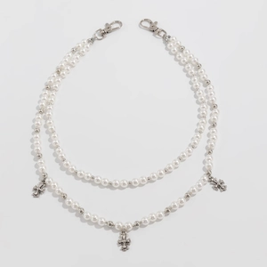 Détail d'une chaîne de taille à double rangée de perles avec pendentifs croix et fermoirs