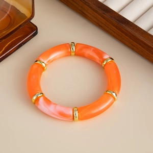 Detail von Marmor-Resin-Armband mit goldenen Abstandsperlen auf schlichtem Hintergrund