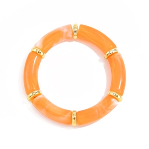 Macro detail of orange marble resin tube bracelet with golden metallic spacer beads