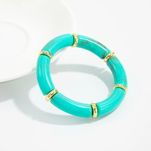 Detail of bohemian turquoise resin tube beads and golden spacers on elastic bracelet