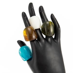 Fashionable thick resin rings in amber, green and blue on model hand detail view