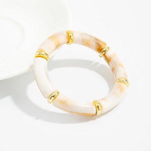 Detailed macro view of acrylic bamboo-style stretch bracelet with gold accent beads