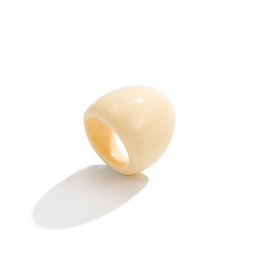 Close-up of a wide chunky cream resin ring featuring a glossy finish and minimalist style