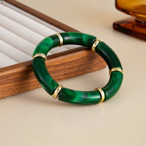 Detailed close-up of dark green malachite texture bamboo bracelet with golden spacer beads
