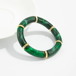 Detail of green malachite resin segments and gold metal beads on elastic bracelet