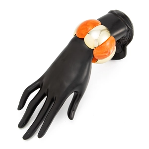 Detail of chunky gold metal and orange marble resin segments on the elastic bracelet