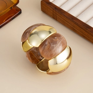 Close-up of golden CCB metal and amber resin chunky elastic bracelet on display