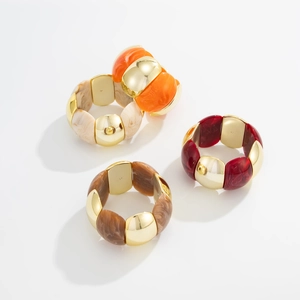 Close-up of wide elastic bracelets with gold CCB links and marble resin modules