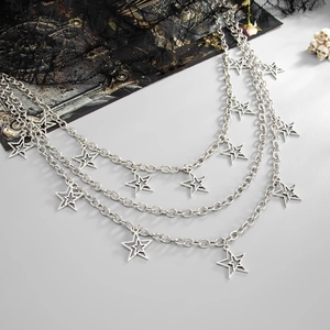 Macro detail of gothic triple-layer metal trousers chain with hollow star pendants