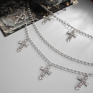 Close-up of triple-layered silver metal waist chain with cross pendants on black lace