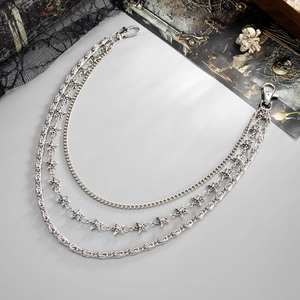 Detailed view of punk multi-layered metal pant chain with stars and gothic accessories