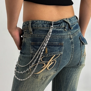 Three-layer silver punk wallet chain with pentagram and cross charms on denim jeans