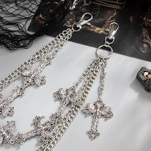 Detailed close-up of punk style silver metal pant chains with cross pendants