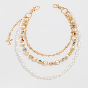 Dettaglio di una catena decorativa a tre strati con perle e strass colorati