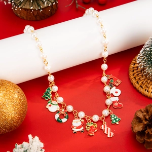 Detail einer Weihnachtskette mit festlichen Anhängern an weißen Kunstperlenperlen