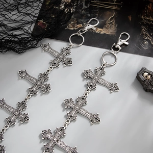 Detail of gothic silver cross charms with star motifs and metal lobster clasp for jeans