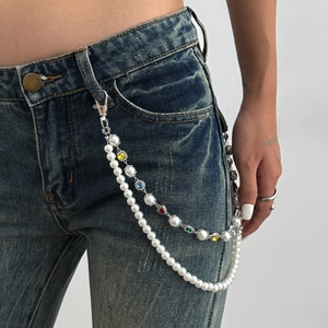 Dettaglio catena per pantaloni a doppio strato con strass colorati e perle finte su denim
