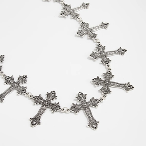 Macro detail of vintage silver cross links with embossed patterns on a metal chain