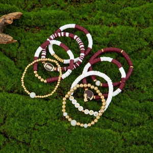 Detail view of Game Day acrylic beaded bracelets with football charms on mossy background