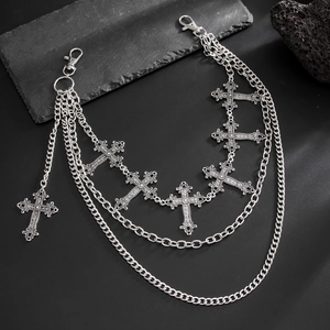 Close-up of layered punk waist chain with vintage silver cross pendants on dark stones