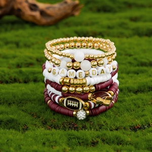 Detail of multi-layer beaded bracelet featuring GAME DAY beads and rugby charms