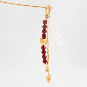 Vintage rose and heart tassel bag chain with pearls and gold beads on minimalist background