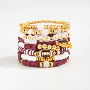 Detail of Game Day bracelet set with rugby charms and red and white heishi beads