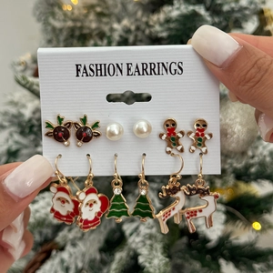 Close-up of a Christmas themed earring set featuring reindeer and gingerbread motifs