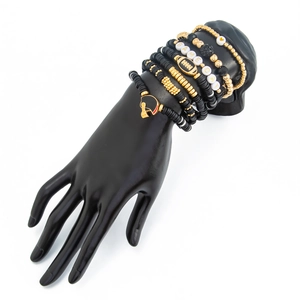 Detail of beaded bracelets with Game Day charms and gold accents on a hand stand
