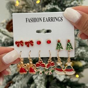 Set of 6 Christmas earrings featuring bells, trees, and bows on festive background